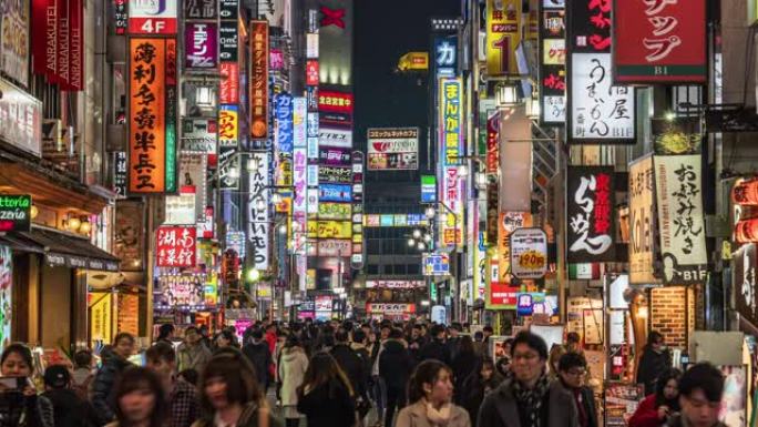 在日本新宿东京市，人群行人在购物霓虹灯街上行走的4k时间流逝与汽车交通在夜间。日本文化与城市生活理念