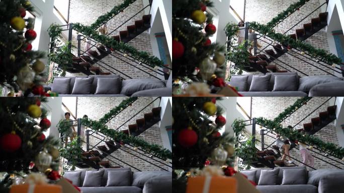 可爱的兄妹在圣诞节早上走下楼梯，惊讶地看着圣诞树上有礼物