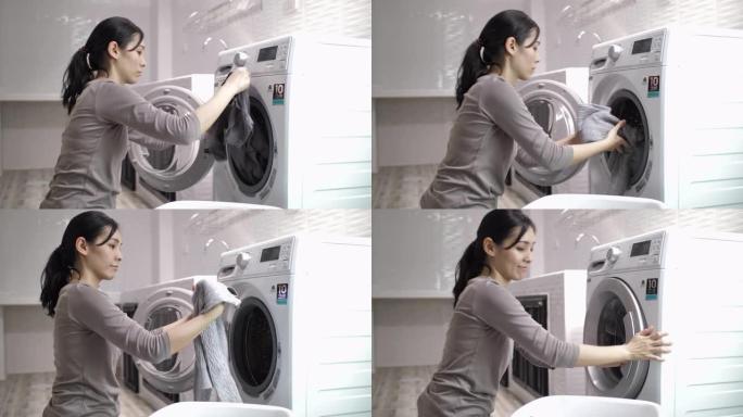 年轻的亚洲妇女在家洗衣服