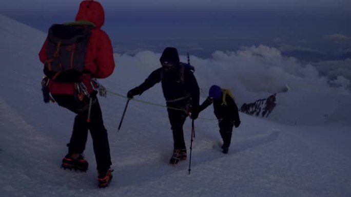 男人正在爬到山顶雪上