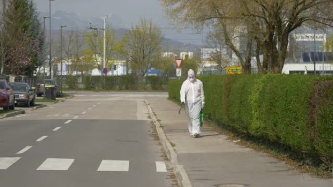 身穿防护服的医学专家对郊区的一条街道进行了净化处理。