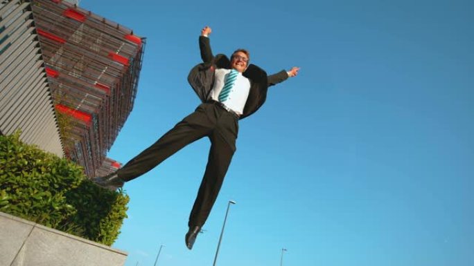 慢动作: 公司专业人士从壁架上跳下来，高高地飞向空中。