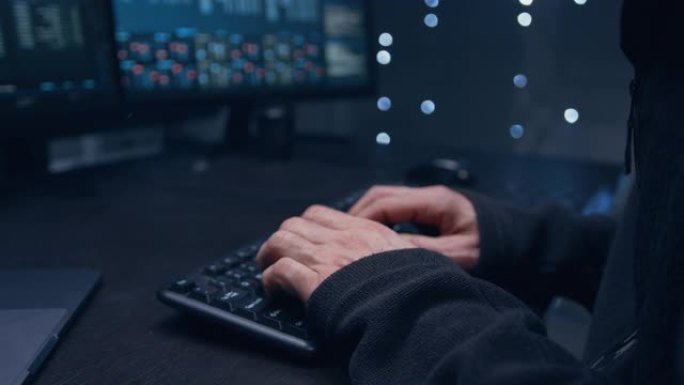 一个男人的手在键盘上打字的特写镜头。在黑暗的服务器室里。