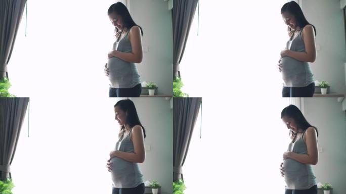 孕妇在客厅看肚子孕育新生命期待新生儿孕妈