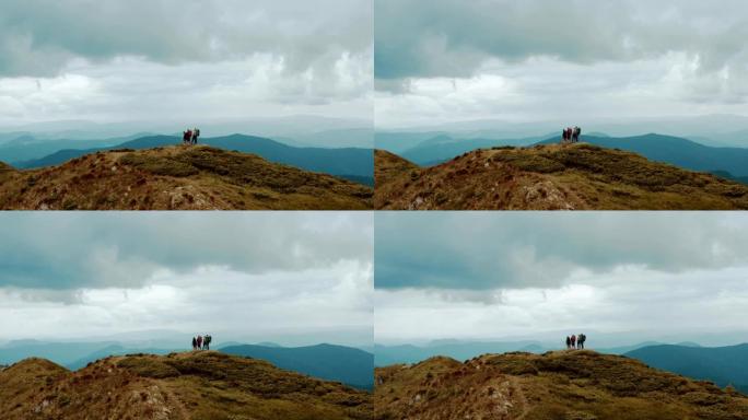 四个背着背包的人站在美丽的山上