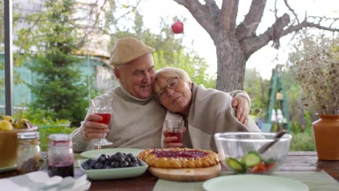 相爱的白人老年夫妇坐在花园里拥抱