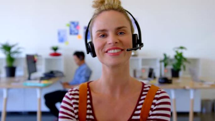 坐在4k办公桌前戴着耳机的白人女性高管
