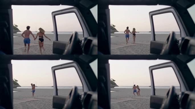 年轻夫妇从汽车跑到海滩