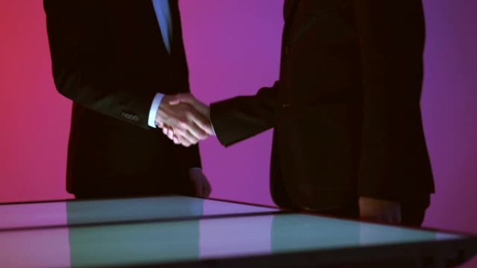两个商人在红底握手。慢动作
