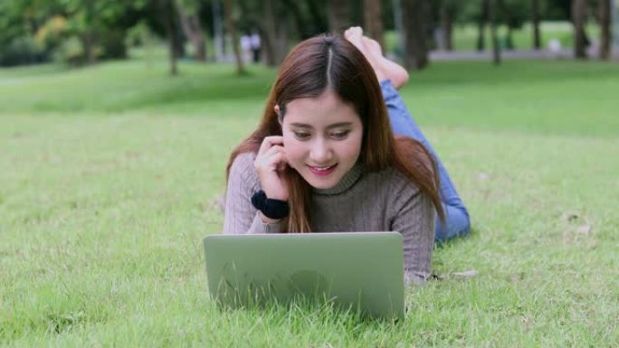 年轻的亚洲女性在户外使用电脑