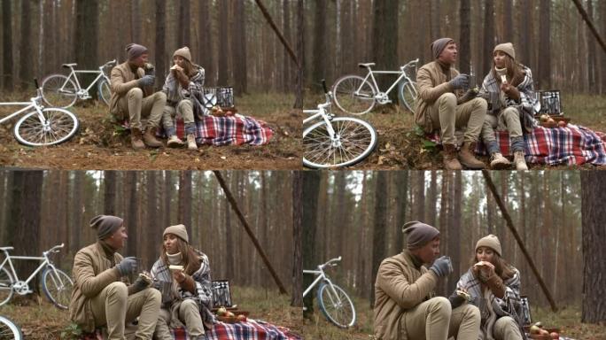 浪漫的情侣在秋季野餐时吃三明治