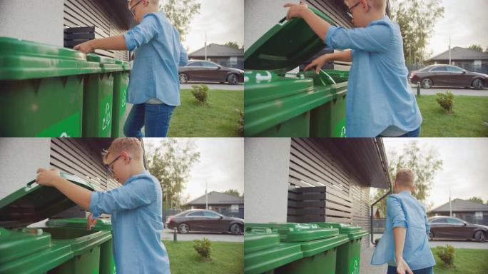 小男孩正走在他家外面，以便将两个空塑料瓶扔进垃圾桶。他使用正确的垃圾箱，因为这个家庭正在分类垃圾并帮