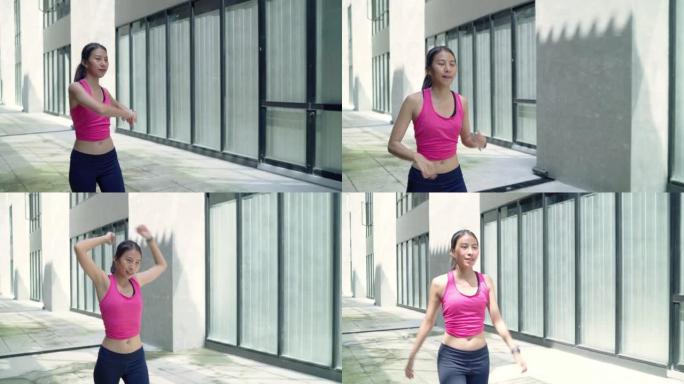 慢动作-健康美丽的年轻亚洲运动员女性运动服腿部温暖和伸展手臂，准备在城市的街道上跑步。城市概念中的生