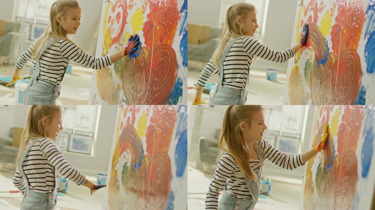 快乐的小女孩，双手蘸上生动的油漆，在墙上画出五颜六色的抽象。她玩得很开心，笑得很开心。家正在装修。