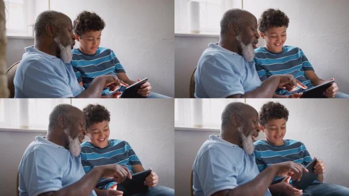 祖父坐在椅子上，孙子解释了如何使用数字平板电脑