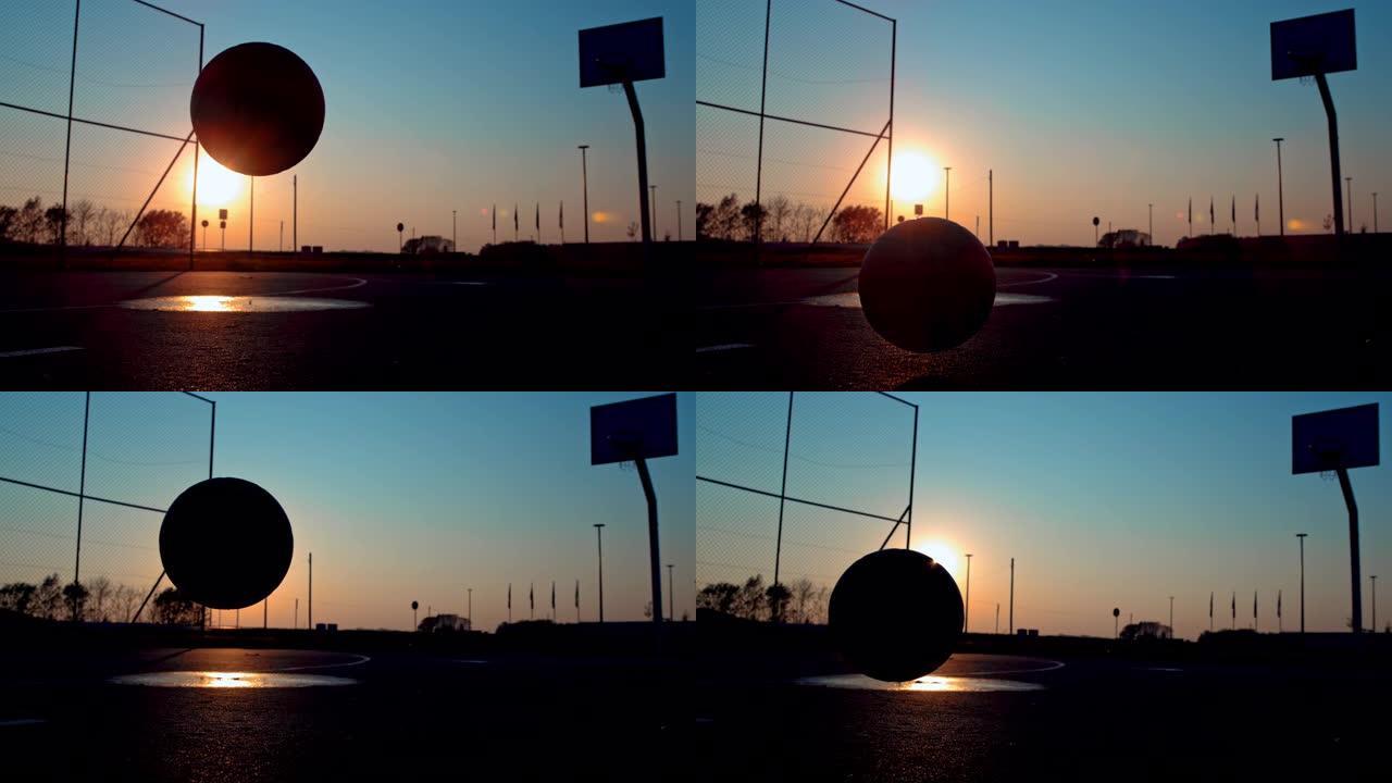 MS超级慢动作剪影篮球在日落时在室外篮球场上弹跳