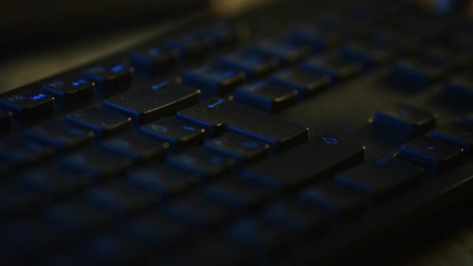 特写微距拍摄: 人使用黑色电脑键盘，按回车键。工作，写电子邮件，使用互联网。深色和蓝色