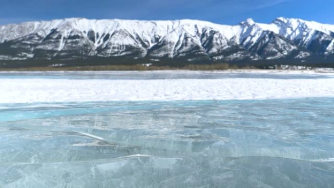 特写镜头，dop: 在艾伯塔省一个冰冻的湖泊后面，一个白雪皑皑的冰川的风景。