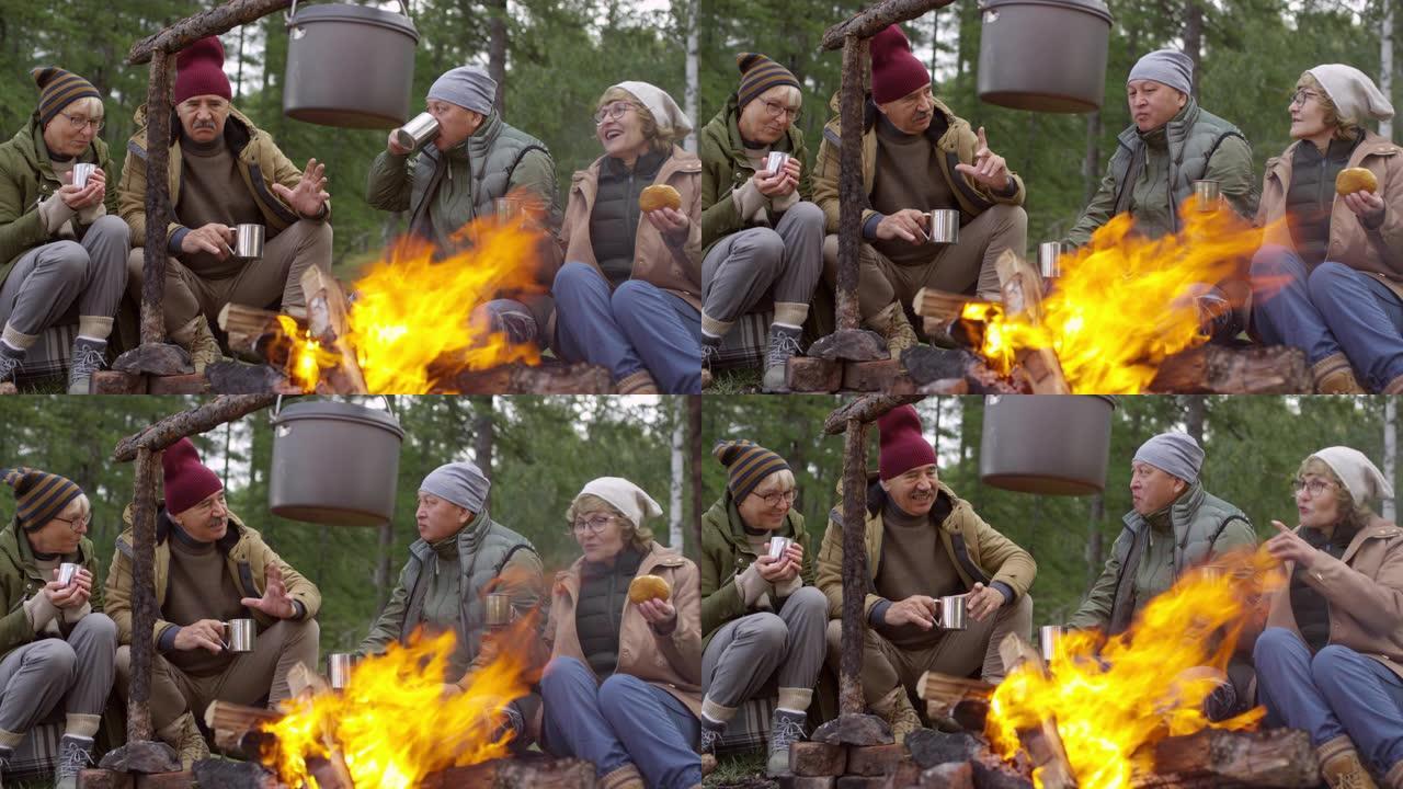 资深朋友在篝火旁喝茶聊天