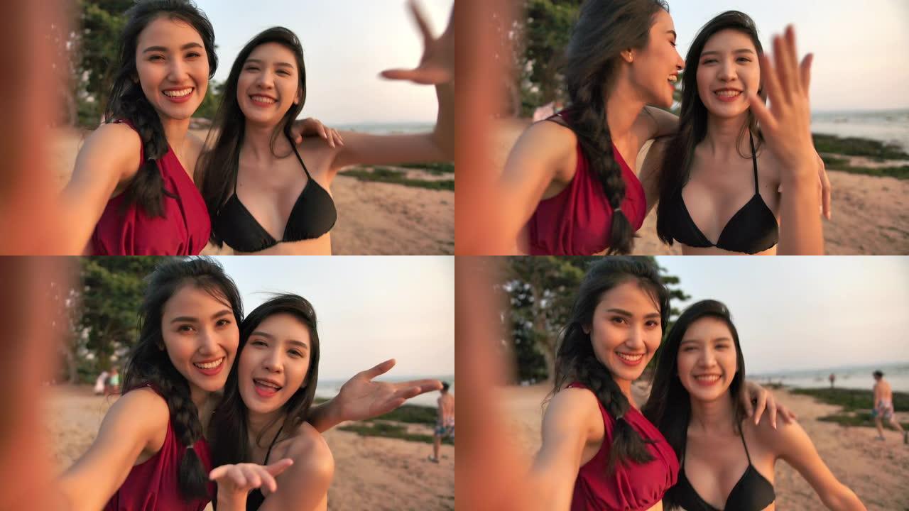 4k分辨率的观点迷人的亚洲女人在海滩上玩得开心，2位美丽的亚洲女人在旅行时看着相机并在线或视频通话
