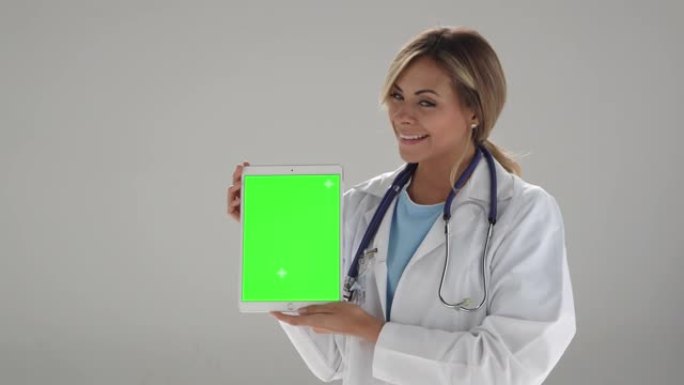 美丽的女医生拿着一个可编辑屏幕的平板电脑-色度键