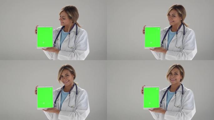 美丽的女医生拿着一个可编辑屏幕的平板电脑-色度键