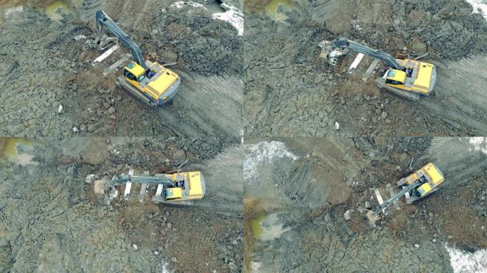 黄色建筑挖掘机在采石场移动重岩石。