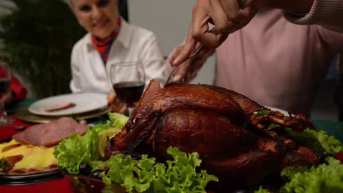 在与家人的感恩节晚餐上，男人切火鸡的特写镜头