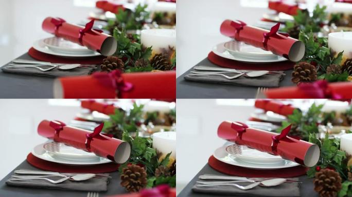 特写镜头，手持镜头显示装饰好的圣诞餐桌上的位置设置，红色圣诞饼干排列在盘子上
