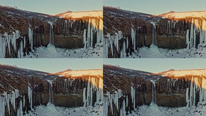 冬天svartivoss瀑布的日落。