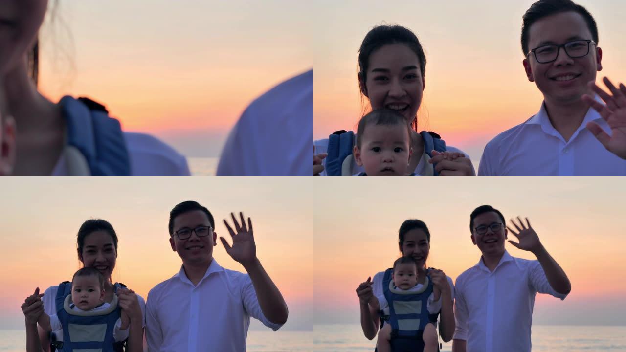肖像亚洲父亲，母亲，宝贝儿子看着相机打招呼。活跃的父母和人们在暑假与孩子一起户外活动。家庭假期快乐。
