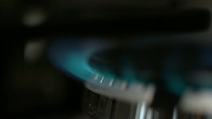 慢动作: 蓝色火焰从大型金属炉灶上的燃气燃烧器中燃烧出来。
