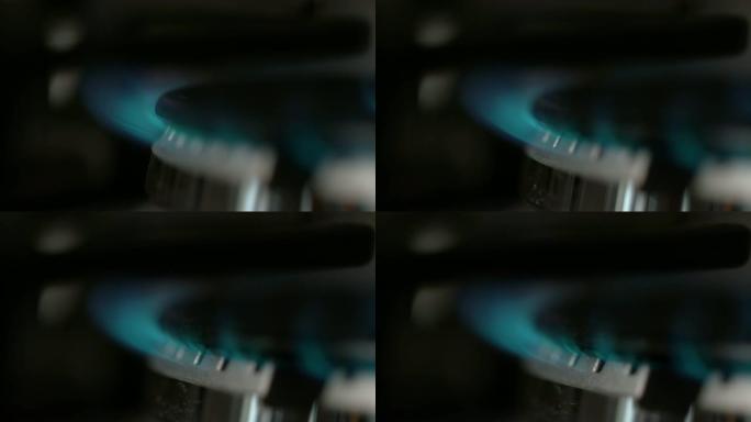 慢动作: 蓝色火焰从大型金属炉灶上的燃气燃烧器中燃烧出来。