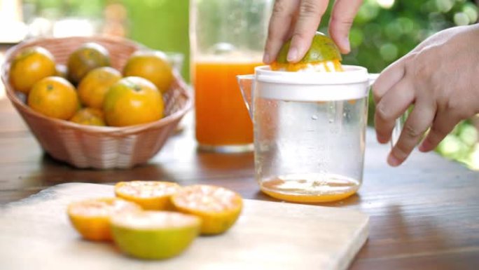 女人用柑橘榨汁机挤压新鲜橙汁
