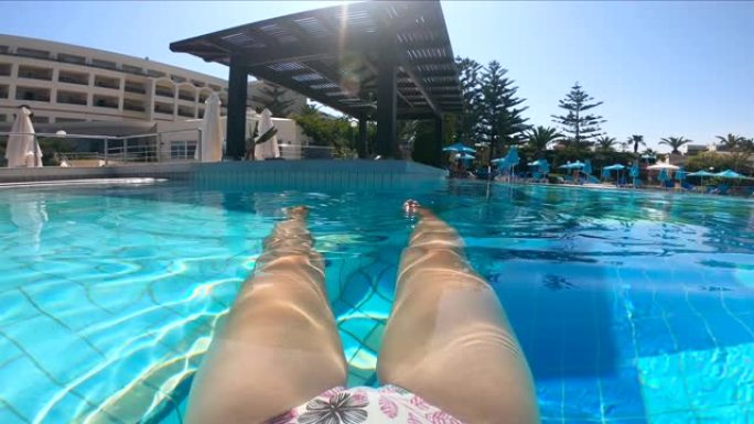 女人在游泳池里休息，享受假期。暑假概念。