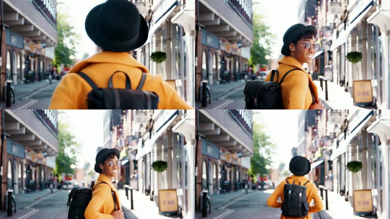 时髦的年轻黑人妇女戴着帽子，穿着黄色豌豆大衣走在街上，转身回头看镜头