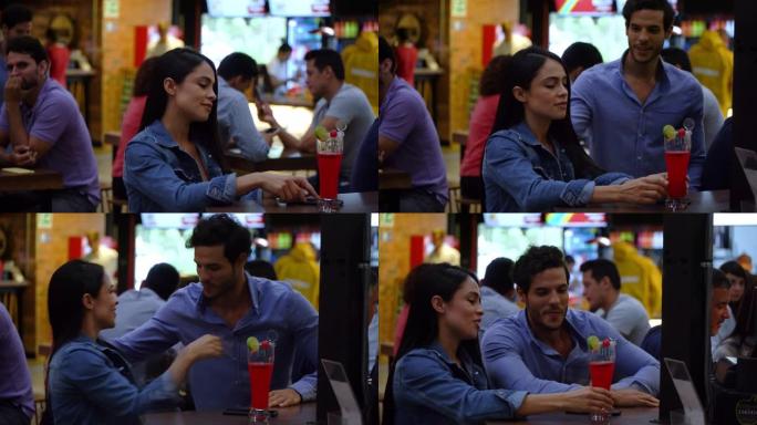 英俊的拉丁美洲男人走近一个坐在酒吧柜台的漂亮女人，用亲吻和拥抱向她打招呼