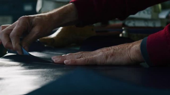 一位鞋匠在一家鞋厂工作，他正在使用意大利传统。