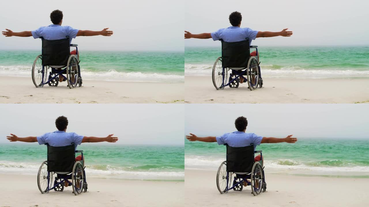 非裔美国人男子的后视图，双臂伸出，坐在轮椅上，双臂伸出