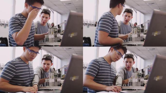 两名在科学机器人或工程课程中使用笔记本电脑建筑机械的男大学生