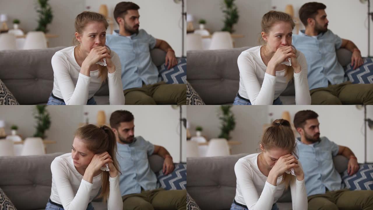 坐在沙发上争吵的夫妇专注于哭泣的女孩