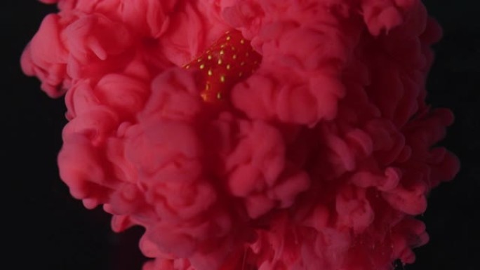 颜色在黑色背景下在空气中油炸的草莓上的爆炸效果。