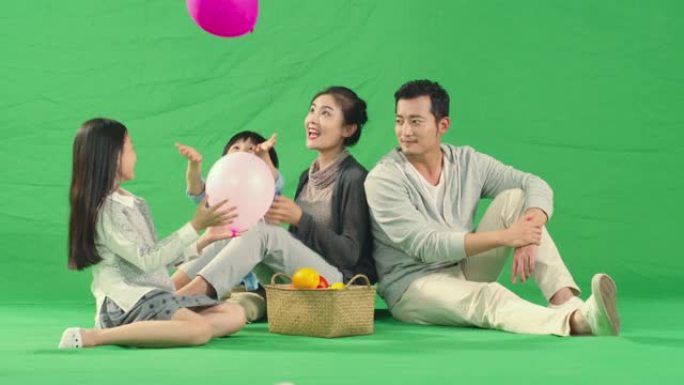 有两个孩子玩气球的快乐亚洲家庭