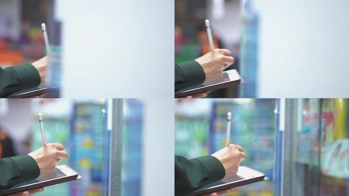 售货员使用数字平板电脑检查超市中的产品，慢动作
