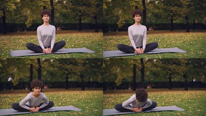 漂亮的黑发女人正坐在瑜伽垫上，以鞋匠的姿势伸展双腿，然后向前弯曲，向后放松，闭上眼睛。放松和瑜伽概念
