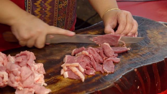 亚洲屠夫用刀切成新鲜的生牛肉