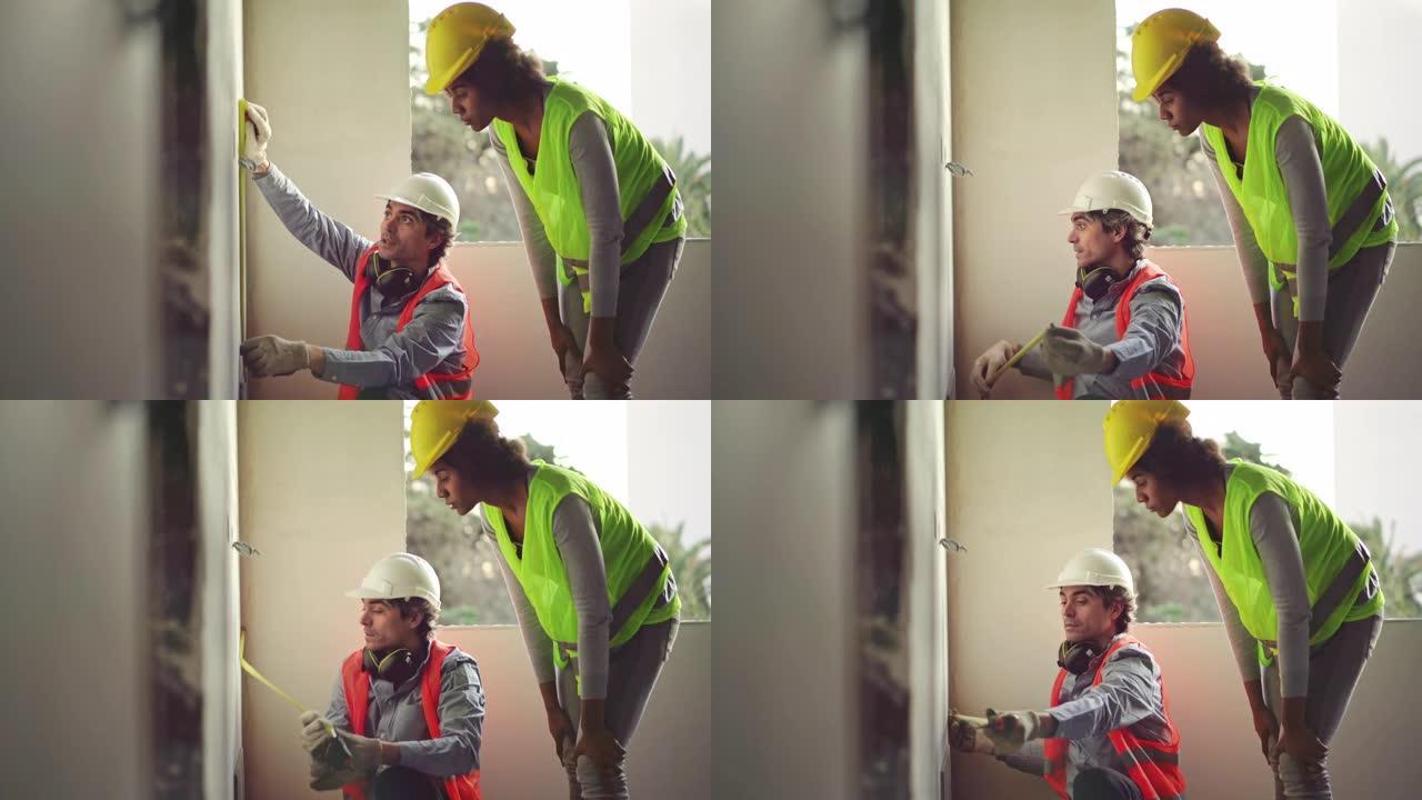 建筑工人在建筑工地测量墙壁