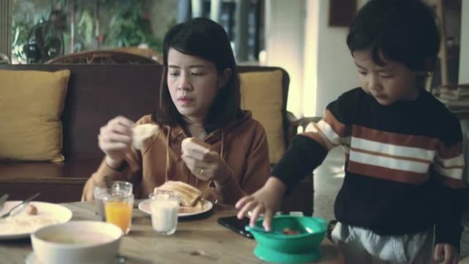 亚洲妈妈和儿子一起吃早餐。