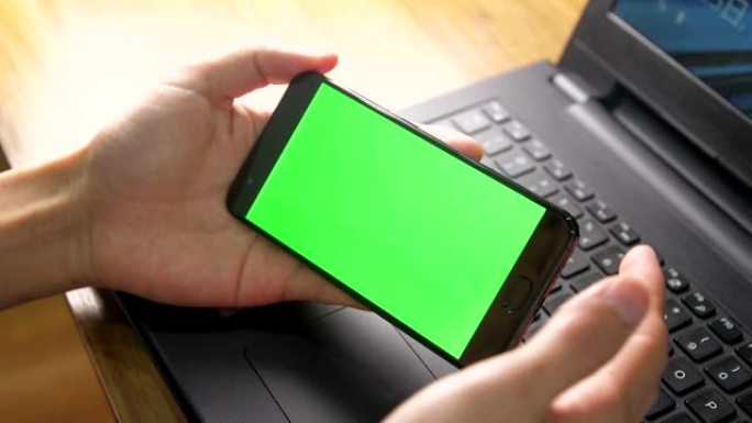 手握手机绿屏显示智能手机打字通话购物自拍