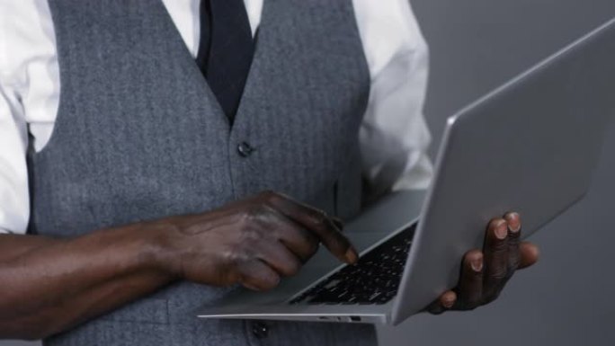 无法识别的非洲绅士使用笔记本电脑